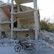 A man rides a motorcycle past a destroyed building in an area that was hit by a reported air strike in the district of Jisr al-Shughur, in the Syrian province of Idlib, on September 4, 2018