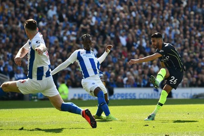 Manchester City's Algerian midfielder Riyad Mahrez (R) scores their third goal during the English Premier League football match between Brighton and Hove Albion and Manchester City at the American Express Community Stadium in Brighton, southern England...