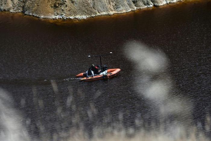 A boat equipped with a sonar system sails on the acidic Red Lake near the village of Mitsero, southwest of Cyprus' capital Nicosia, searching for bodies of victims of a suspected serial killer
