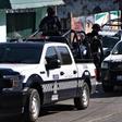 Police stationed outside the house in Veracruz where 13 people were killed in a shooting on Friday