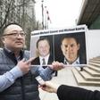 Louis Huang of Vancouver Freedom and Democracy for China holding photos of Canadians Michael Spavor and Michael Kovrig