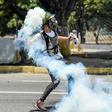 An anti-government protester throws Molotov cocktails during clashes with security forces near the La Carlota military base in Caracas