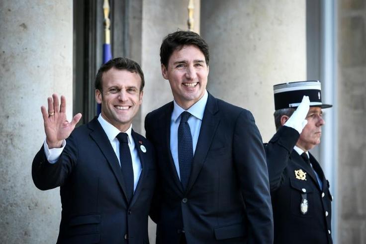 French President Emmanuel Macron (l) welcomes Canadian Prime Minister Justin Trudeau upon his arrival at the Elysee Palace in Paris