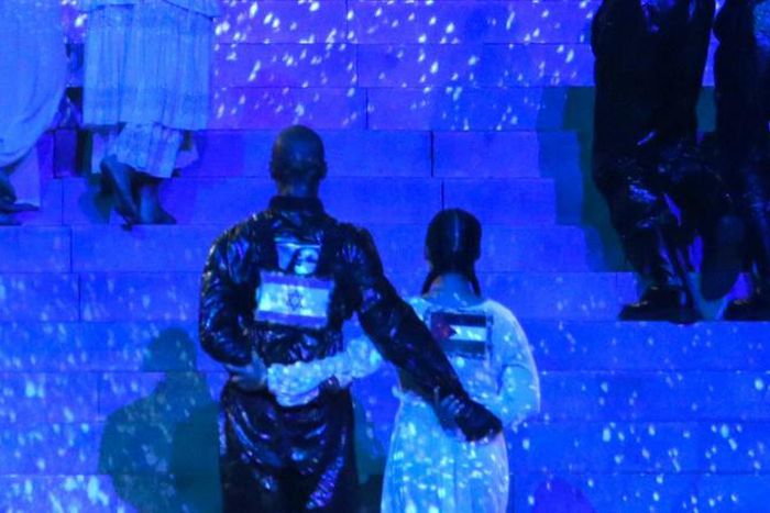 Two of Madonna's dancers are seen side-by-side with Israeli and Palestinian flags on their backs during her performance at Eurovision