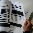 A journalist reads a redacted court filing from Special Council Robert Mueller; many worry that key parts of his final report will be similarly censored
