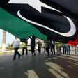 Libyans wave a giant national flag during a demonstration in Tripoli on Friday, in protest against strongman Khalifa Haftar