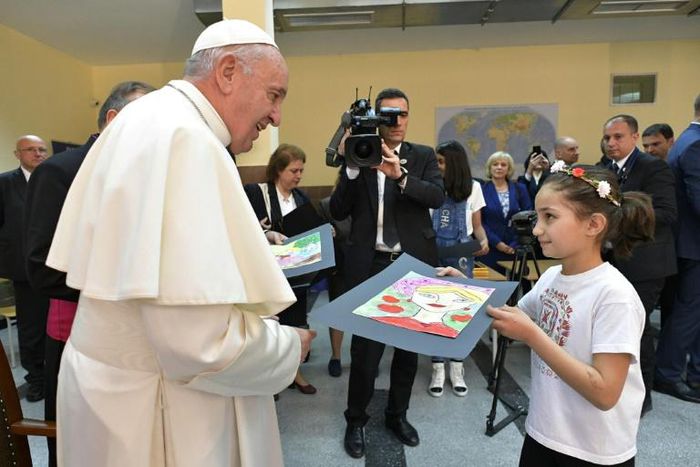 Pope Francis meets a young girl in a refuge camp in Bulgaria where he spoke of their sufferings and the need for others to help them