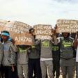 Migrants hold placards during United Nations Secretary-General Antonio Guterres (unseen) visit to Ain Zara detention centre for migrants in the Libyan capital Tripoli on April 4, 2019