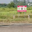 A Vietnamese soldier stands next to a sign warning of toxic hazard at Bien Hoa air base, on the outskirts of Ho Chi Minh City