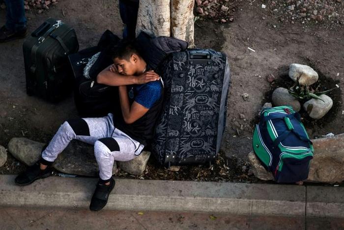 An asylum seeker rests outside El Chaparral port of entry while he waits for his turn to present himself to US border authorities to request asylum, in Tijuana, Mexico, on April 9, 2019