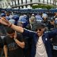Algerian security forces stand guard behind protesters in the capital Algiers on Friday