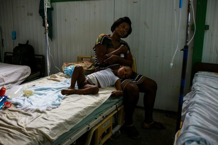 A young patient lies on his mother's lap at the postoperative ward during a doctors' strike at the public hospital in Port-au-Prince