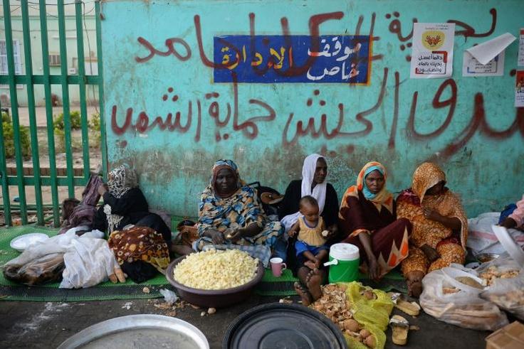 Sudanese women prepare food to be served during the Iftar (breaking of the fast) at sunset during the Muslim holy month of Ramadan, as they protest outside the army headquarters in the capital Khartoum