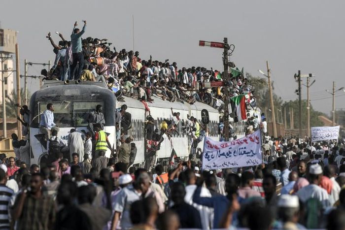 Sudanese protesters from the city of Atbara -- where demonstrations against deposed president Omar al-Bashir began more than four months ago -- cheer upon arrival at Bahari station in Khartoum on Tuesday
