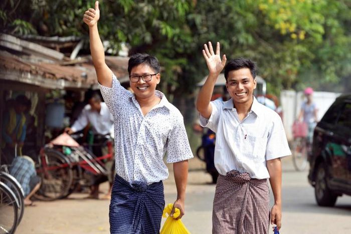 Journalists Wa Lone and Kyaw Soe Oo gesture as they walk out of Insein prison gate after being freed in a presidential amnesty in Yangon on May 7, 2019
