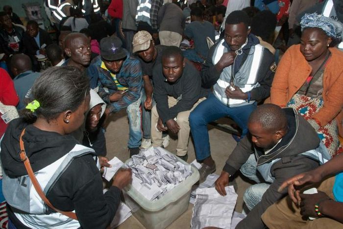 Polling staff and party monitors count votes at a polling station in in Blantyre