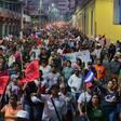 Thousands of Hondurans marched through the capital to protest against new laws they say will lead to mass layoffs