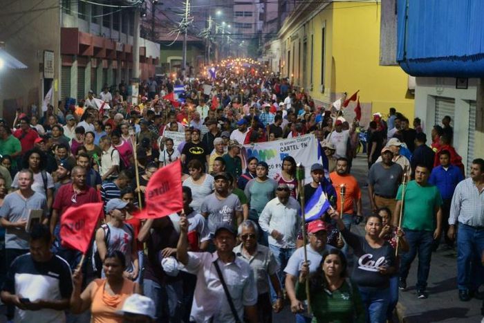 Thousands of Hondurans marched through the capital to protest against new laws they say will lead to mass layoffs