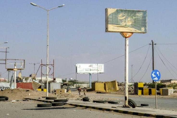 Members of the Yemeni pro-government forces (pictured November 2018) walk through destruction in an industrial district in the eastern outskirts of the port city of Hodeida, where Huthi rebels will begin a pullback