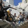 White Helmet rescuers and civilians extract a child from the rubble of a building destroyed during an air strike reportedly by Syrian regime forces and their allies on the town of Ariha, in Syria's Idlib province on May 27, 2019