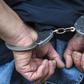A handcuffed suspect arrested during a past event (Twitter)