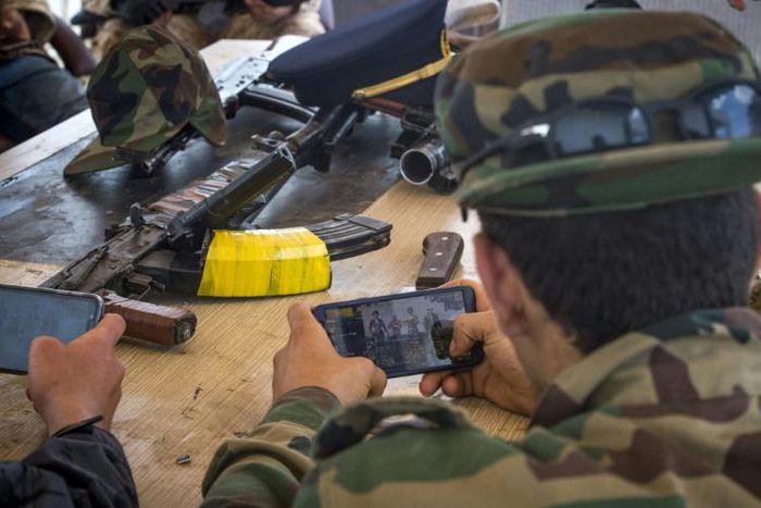 Fighters loyal to the internationally recognised Government of National Accord take a break from the front line to play an online combat game on their phones at their base in Tajoura, south of the Libyan capital Tripoli