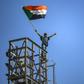 A protester waves a Sudanese flag on top of a tower during a sit-in outside the army headquarters in the capital Khartoum on April 30, 2019