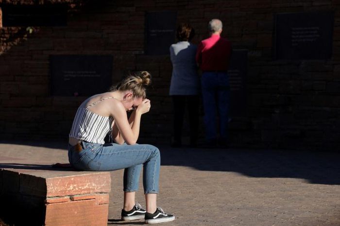 Maren Strother, 16, rests her head on her hands at a vigil in Littleton, Colorado to the April 20, 1999 mass shooting at Columbine High School