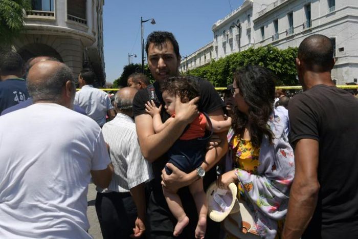 People at the scene of a blast that targeted police on the Tunisian capital's main avenue on Thursday