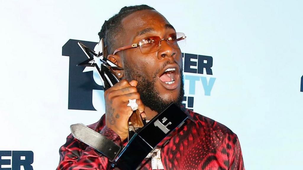 Burna Boy with his BET trophy after the winning. [Instagram/MTVBase]