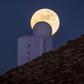 (FILES) In this file photo taken on December 13, 2016 the full moon is seen behind a telescope of the Spain's Institute of Astrophysics of the Canary Islands, in the National Park of El Teide, on the Spanish canary island of Tenerife on December. A tea...