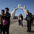 Tourists from China pose for photos before the Three Charters monument in the North Korean capital Pyongyang