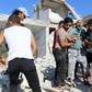 Syrian civilians help a wounded man following reported air strikes by regime forces on Maaret al-Numan in Syria's northwestern Idlib province on July 23, 2019