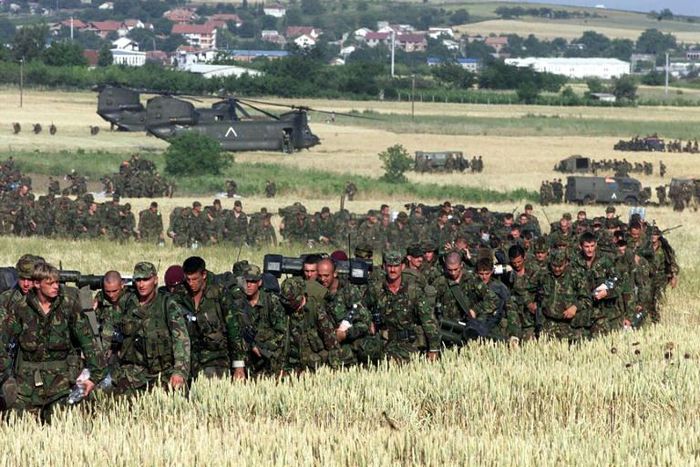 British troops march through a cornfield on the border with neighbouring Macedonia, headed into Kosovo on 11 June 1999 as part of a NATO ground force