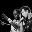 Johnny Clegg (R) performed in the band Savuka for years under apartheid until group member Dudu Zulu (L) was shot dead in 1992 and dancer Dudu Zulu of South African band Savuka perform on stage at the Amnesty International Concert on October 10, 1988 i...
