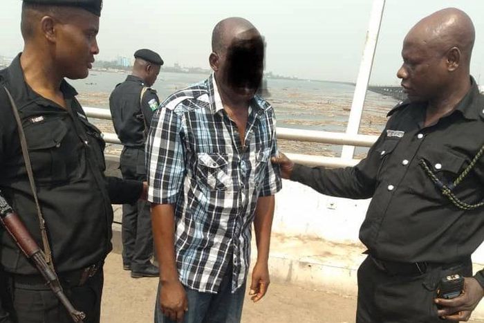 Police officers take a man into custody after a failed suicide attempt on the Third Mainland Bridge in January 2019 [RRS]