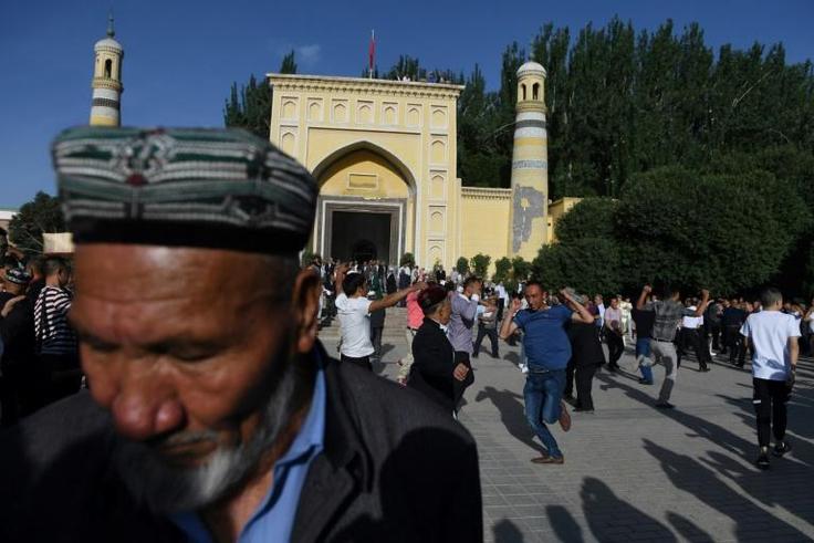 Uighur men dance after Eid al-Fitr prayers in Kashgar, in China's western Xinjiang region