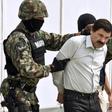 Joaquin "El Chapo" Guzman is escorted by marines as he is presented to reporters in Mexico City soon after his arrest in February 2014