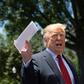 US President Donald Trump shows reporters a piece of paper that he said contained details of tough new concessions that he had extracted from Mexico on the migration issue