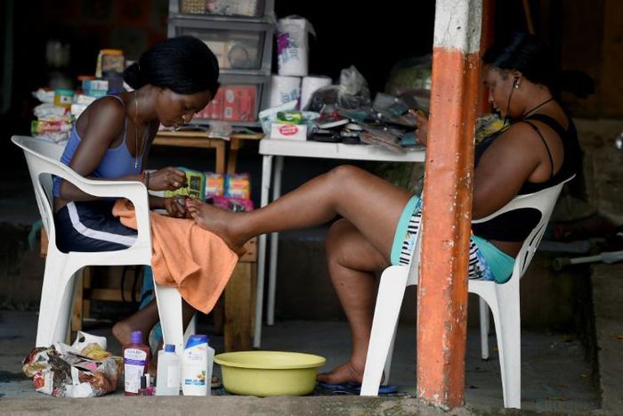 Migrants from Haiti and African countries stuck in the Mexican town of Tapachula do menial work to get by, such as giving pedicures