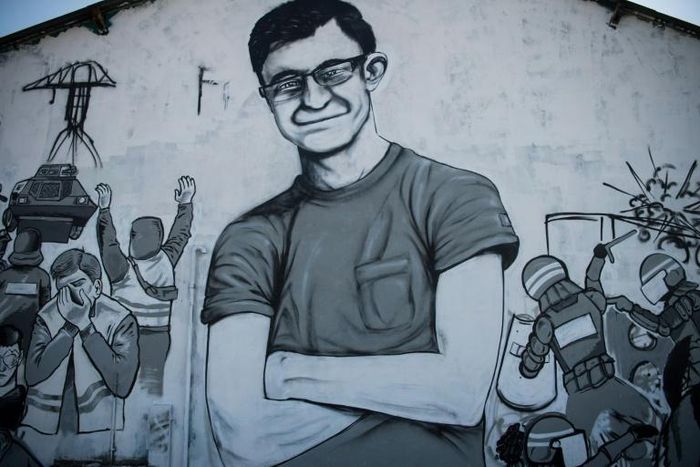 A mural in Nantes depicts a portrait of Steve Maia Canico (C) amid scenes of police violence, after he went missing last month