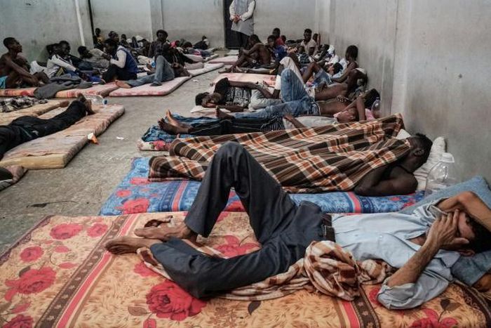 (FILES) In this file photo taken on June 17, 2017 illegal immigrants are seen sleeping at a detention centre in Zawiyah, 45 kilometres west of the Libyan capital Tripoli. The heads of two refugee agencies have called for refugees and migrants held in L...