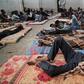 (FILES) In this file photo taken on June 17, 2017 illegal immigrants are seen sleeping at a detention centre in Zawiyah, 45 kilometres west of the Libyan capital Tripoli. The heads of two refugee agencies have called for refugees and migrants held in L...