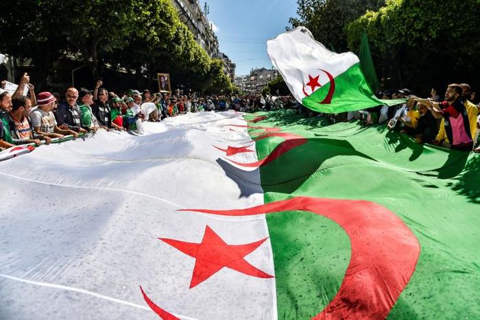 Algerian protesters march with a giant national flag during a demonstration in the capital Algiers on May 31, 2019