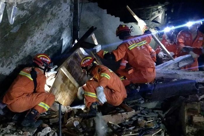 Rescuers search for earthquake survivors in the rubble of a building in Yibin, in China's Sichuan province
