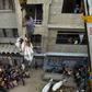 A bull is lowered by crane from the roof of a building in preparation for the annual Muslim festival of Eid al-Adha in Karachi