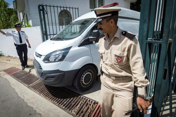 Moroccan security personnel stand guard as a car transporting the suspected killers leaves the court in Sale on May 16
