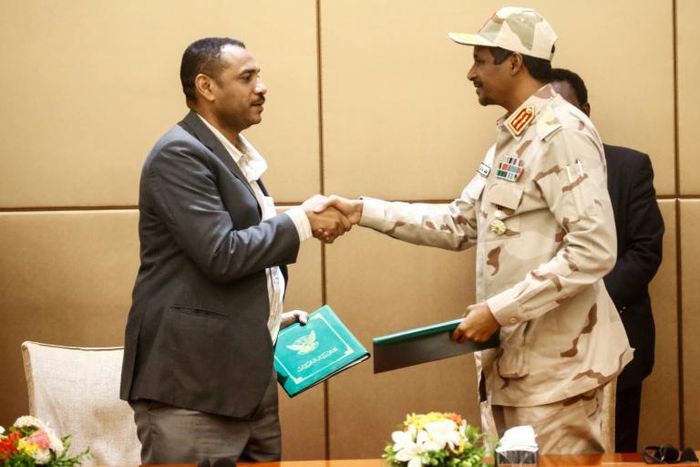 General Mohamed Hamdan Daglo (R), deputy head of Sudan's ruling military council, and protest movement leader Ahmed Rabie shake hands after signing the constitutional declaration at a ceremony in Khartoum