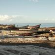 Malawian fishermen fix their fishing nets on the shores of Lake Malawi where fish stocks are falling due to overfishing and climate change