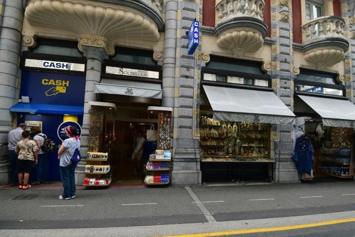 Pope Francis says he wants to see less commercialism and more piety in the Marian shrine in the French southwestern pilgrimage city of Lourdes. Visitors wait to withdraw money from a cash dispenser next to shops selling religious articles